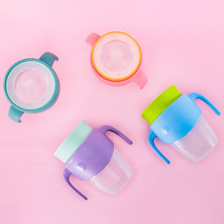 four different colored 360 cups against a pink background