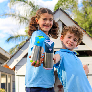 two young children wearing blue shirts smile at the camera and hold up insulated water bottles