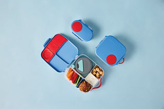 a blue b.box bento lunchbox, a mini lunchbox, and a snack box against a light blue background