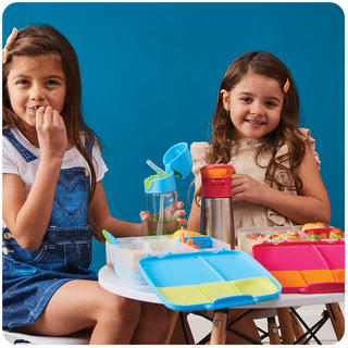 two girls eating lunch from lunchboxes
